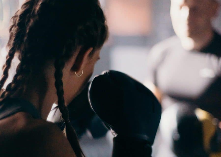 Man and woman practising boxing with gloves and pads