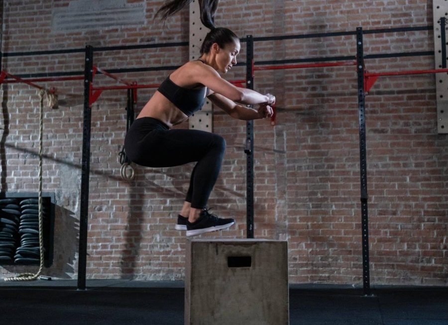A woman performing plyometric exercise jumping onto a box