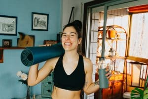smiling woman with nc fitness gym equipment working out at home